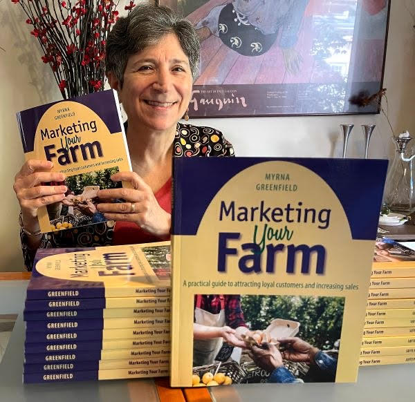 Author Myrna Greenfield holds a copy of her book, Marketing Your Farm