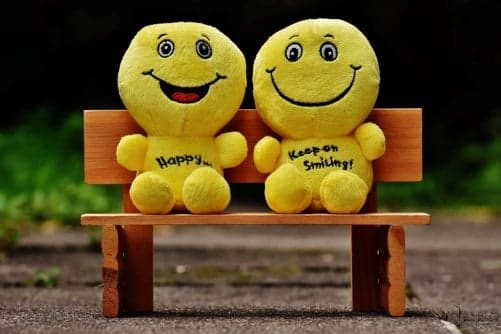 Image of two cartoonish puppets on a bench